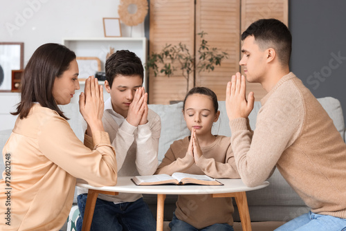 Family praying with Holy Bi...