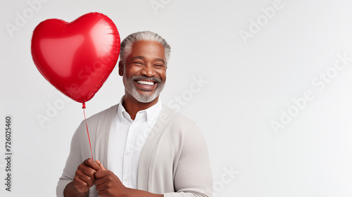 Valentine's Day Attractive Mature African American Man Smiling and Holding A Big Red Balloon © Mircea Maties
