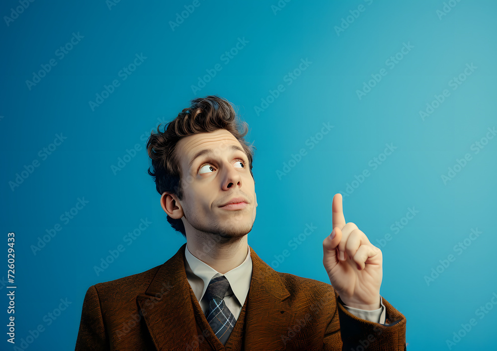 happy young male pointing a finger against blue background happy young male pointing a finger against blue background