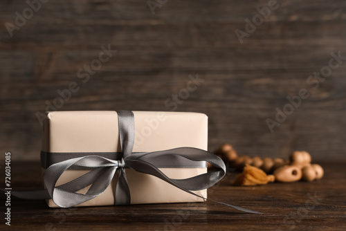 Gift box with prayer beads for Ramadan on wooden table