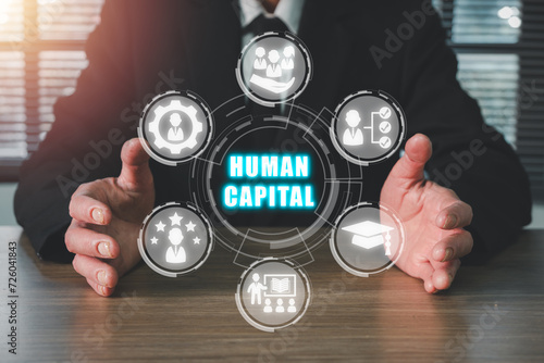 Obraz na płótnie Human capital concept, Businessman hand holding human capital icon on virtual screen