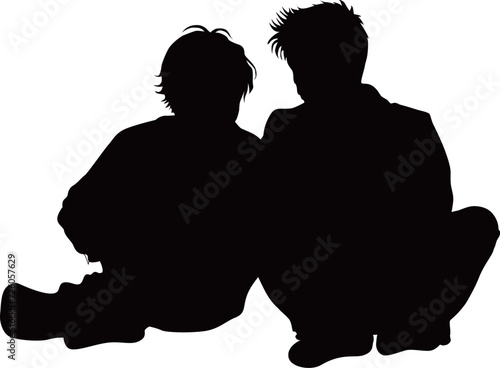 地面に座って体を寄せた10代の男子2人シルエット