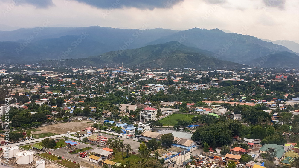 Aerial scenic landscape view of capital city of Dili nestled at the base of mountains on the tropical island of Timor-Leste in Southeast Asia Aerial scenic landscape view of capital city of Dili nestled at the base of mountains on the tropical island of Timor-Leste in Southeast Asia