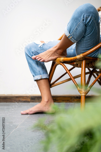 Woman sitting on wooden armchair on the balcony.