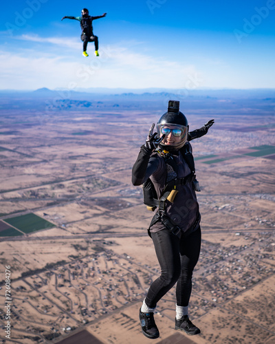 Happy woman skydiver smiling in freefall over the desert