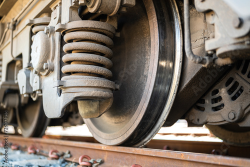 Heavy steel of train wheel on the track, transportation equipment. Close-up and selective focus on the vehicle part.