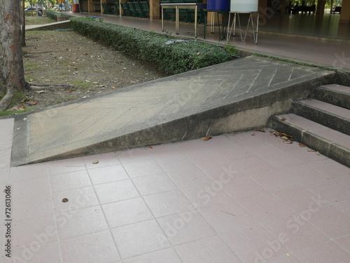 Disabled ramp or incline concrete installed at the public park beside the stair. Standard construction for handicap and old aged people in Asia. 