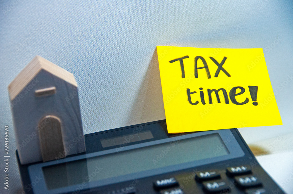 Tax time reminder on yellow sticky note remark for business and individual tax plan budget 2024 copy space stock photo white background on calculator and wooden handmade house toy Tax time reminder on yellow sticky note remark for business and individual tax plan budget 2024 copy space stock photo white background on calculator and wooden handmade house toy