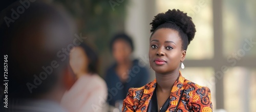 Confident African businesswoman engages in dialogue at a corporate event. photo