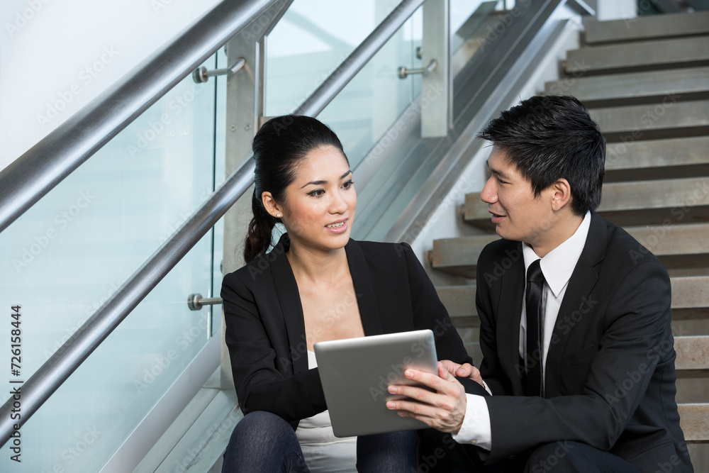 Asian Businessman and woman using tablet.