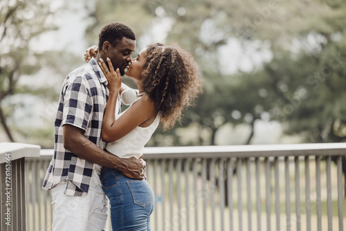 Date couple man and women kiss valentine day. African black lover kissing at park outdoors summer season vintage color tone