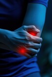Acute pain in the elbow of a woman on a dark background.