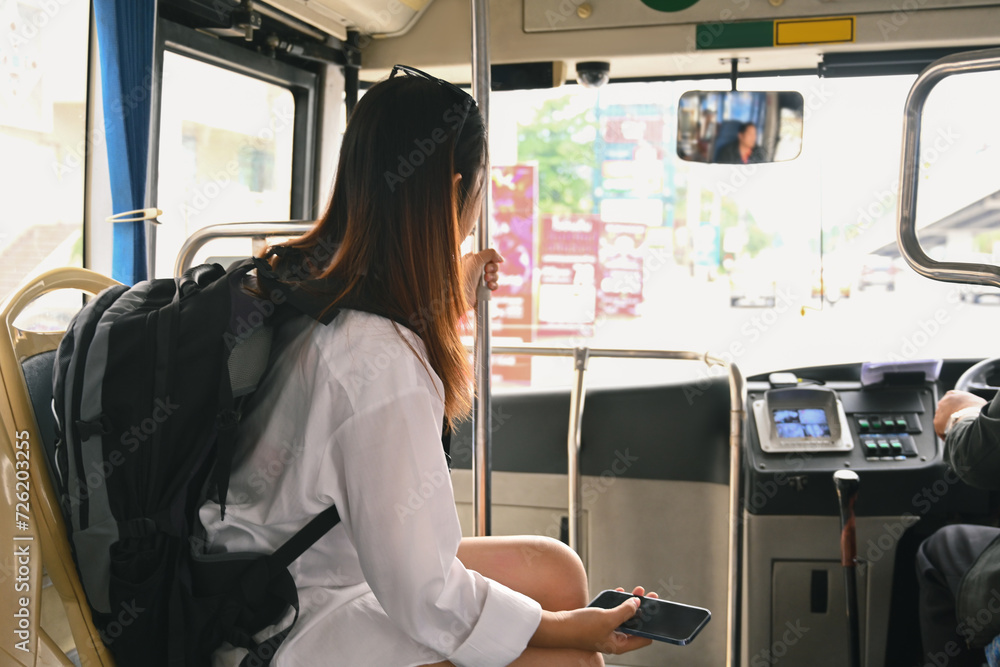 Female traveler with backpack sitting in public transportation. Travel lifestyle and transportation concept Female traveler with backpack sitting in public transportation. Travel lifestyle and transportation concept