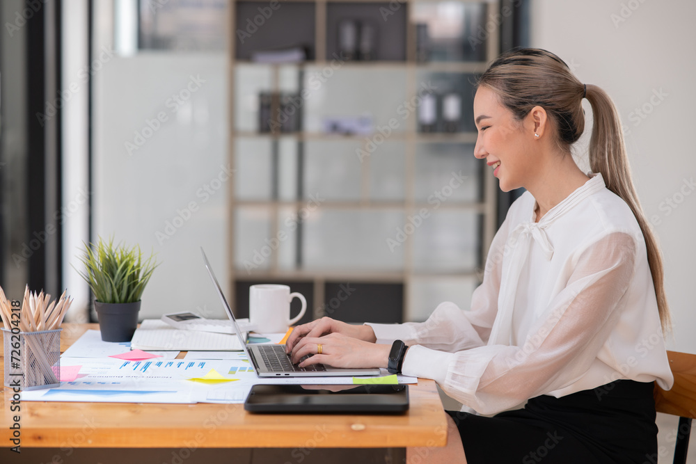 Asian businesswoman holding notebook about business, spending money Asian businesswoman holding notebook about business, spending money
