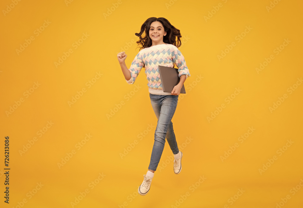 School student using laptop. E-learning and online education. Run and jump, jumping kids. Teen girl on internet video chat isolated on isoalted studio background. School student using laptop. E-learning and online education. Run and jump, jumping kids. Teen girl on internet video chat isolated on isoalted studio background.