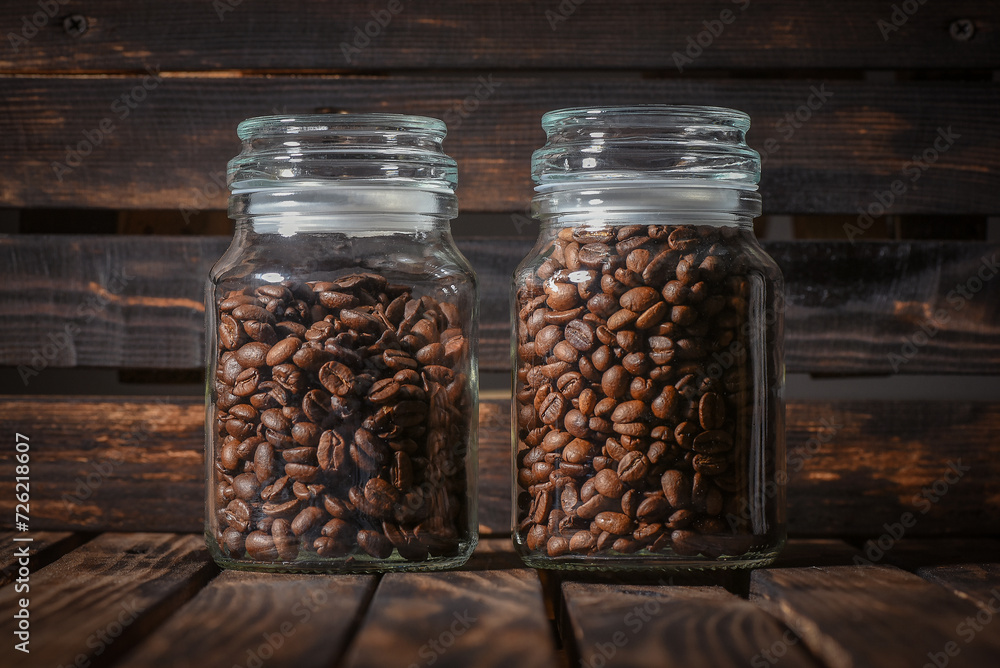Coffee beans in the jar on the table front view close up background. Coffee beans in the jar on the table front view close up background.