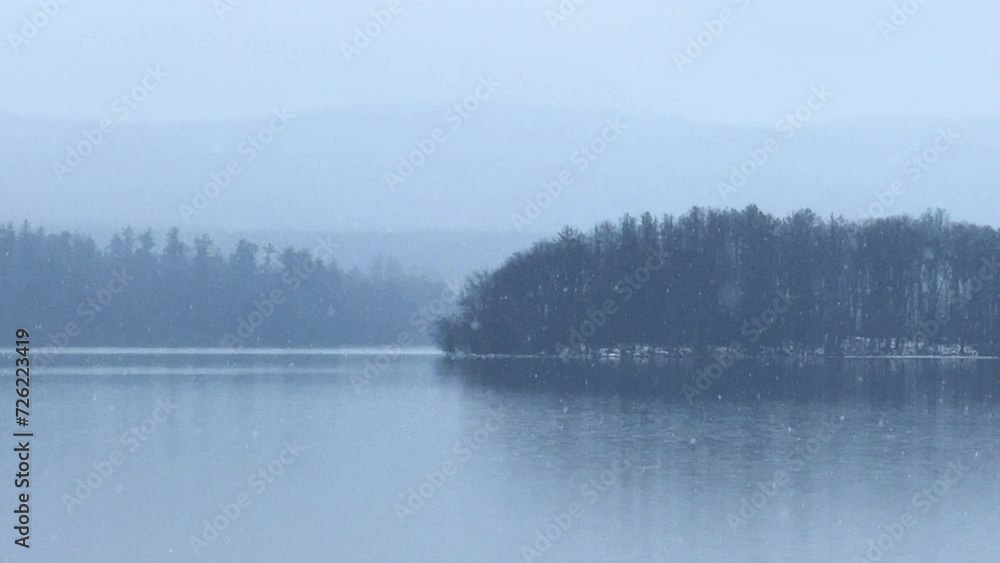 Beautiful and calm gentle snowfall over a calm, quiet mountain lake Beautiful and calm gentle snowfall over a calm, quiet mountain lake