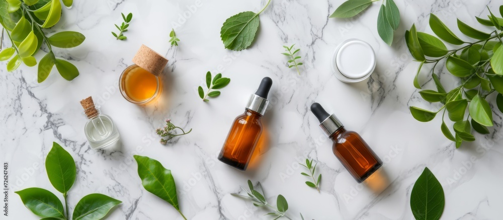 Top view flat lay of laboratory glassware and cosmetics serum with fresh leaves on a marble background, ideal for organic cosmetics and SPA branding.