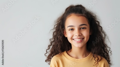 Smiling multiethnic girl isolated on grey  space for message