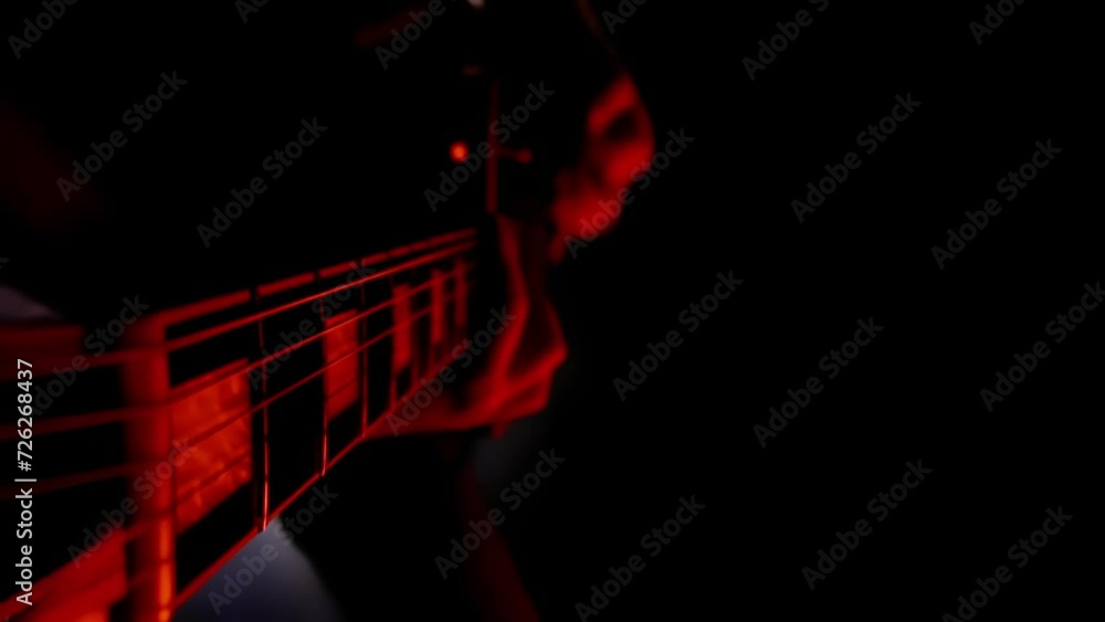 Fingers hitting strings on electric guitar, close up headstock