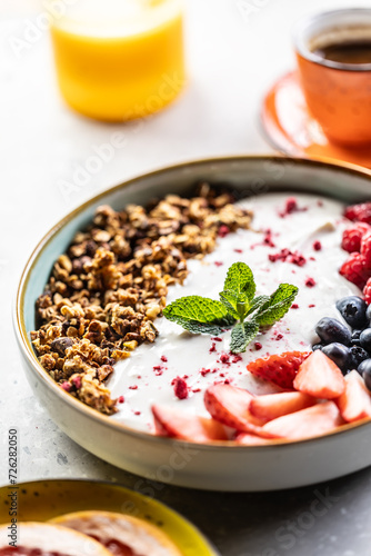 A bowl full of berries, yogurt and cereal. Healthy breakfast concept