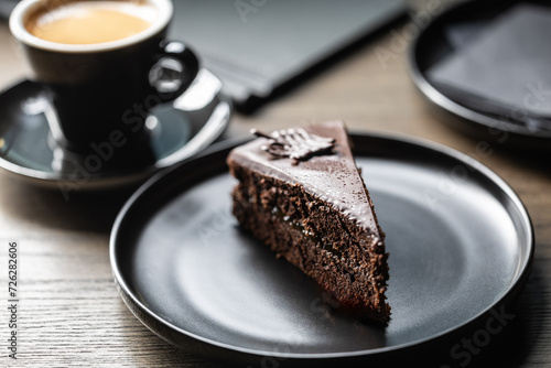 Sacher cake with coffee on the table in the cafe. photo