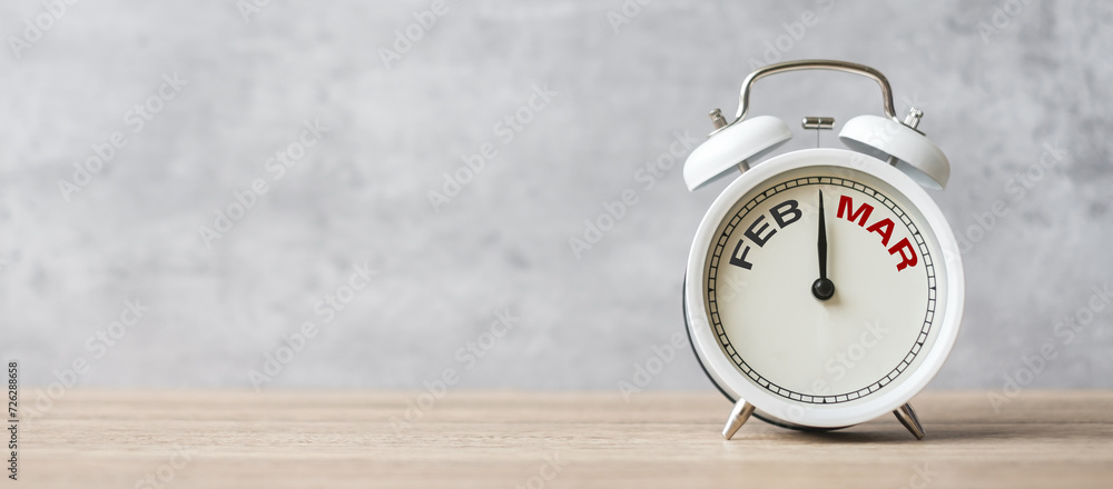 Hello March Changed from February  month with vintage alarm clock on table background. Calendar, Monthly, New Start, Resolution, Goals, Plan, Action and Mission Concept - obrazy, fototapety, plakaty 