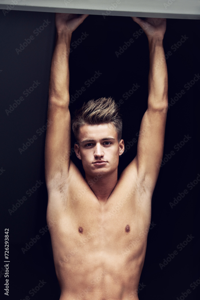Shirtless, body and portrait of young man looking serious on a dark background with strength. Topless, muscles and face of a caucasian male person from Norway with confidence and pride for his chest