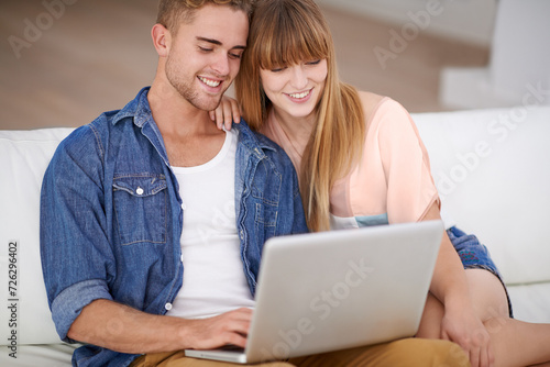 Happy, couple and relax with laptop on sofa to watch movies with subscription for streaming in home. Online, man and woman reading on couch and scroll the news on website, blog or social media