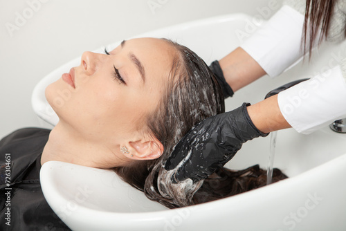 Hairdresser washing hair of a woman in a beauty salon