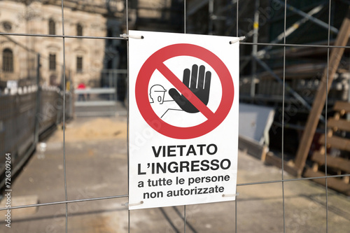 Cartello vietato l'ingresso posto su una rete metallica all'inizio di un cantiere. Sfondo sfocato, focus sul segnale in primo piano. photo