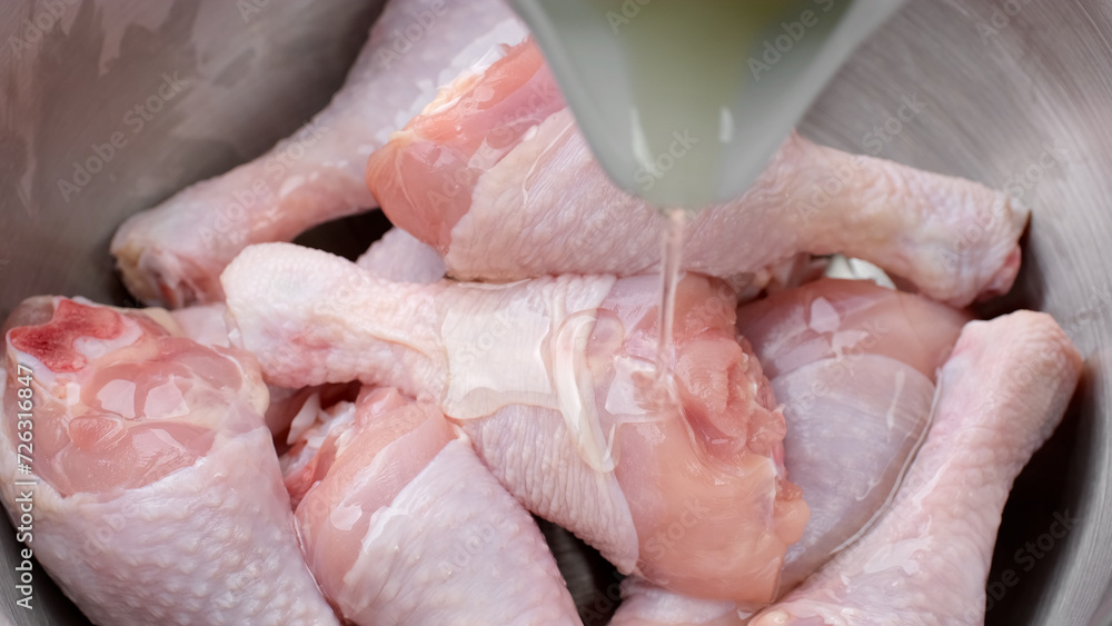 Fototapeta premium Process marinated raw chicken legs in olive oil