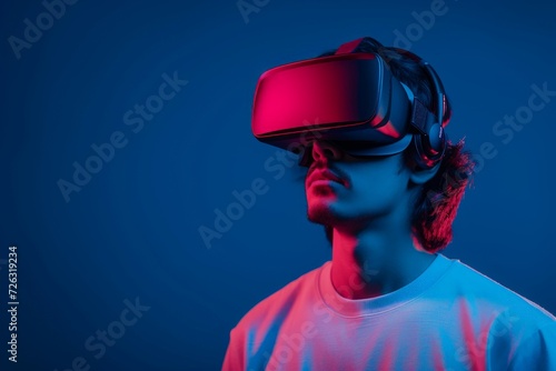 Young man with virtual reality headset in neon lighting. Virtual reality, augmented reality concept. VR / AR metaverse simulation. Futuristic technology and future. Design for banner with copy space © dreamdes