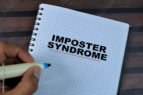 Quadro em tela Concept of Imposter Syndrome write on book isolated on Wooden Table