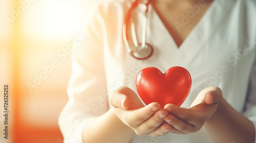 Doctor holding red heart symbol of life photo