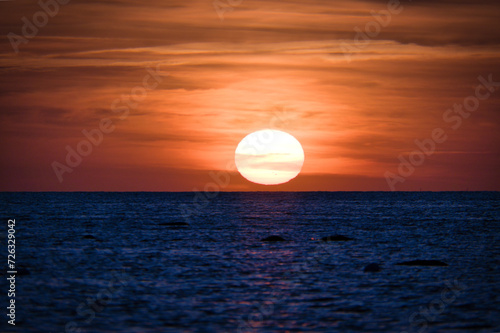 Fototapeta Naklejka Na Ścianę i Meble -  Sunset over the Baltic Sea. The red sun sinks into the sea. Evening atmosphere
