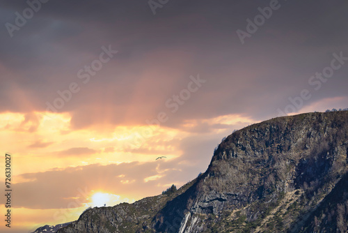 Westcap in Norway. Mountain that reaches into the fjord. Cloudy sky with clouds photo