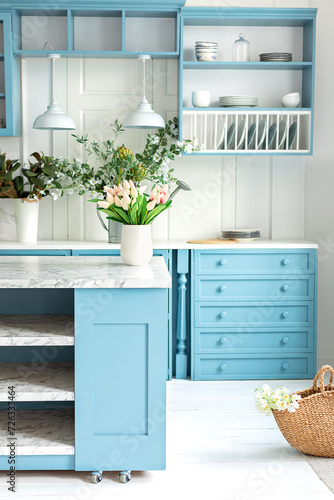 Wallpaper Mural Kitchen island in dining room. Stylish cozy cuisine with tulips flowers in vase. Wooden kitchen in spring decor. Kitchen utensil, dishes and plate on shelves. Blue kitchen interior with furniture Torontodigital.ca