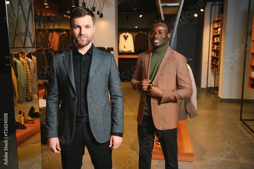 Two handsome respectable men in elegant classic suits in a premium men's clothing store photo