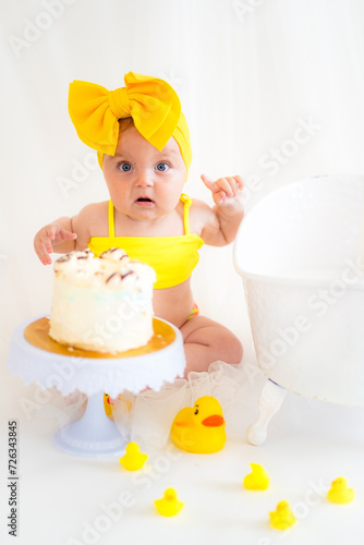 Girl in a yellow swimsuit and birthday cake
