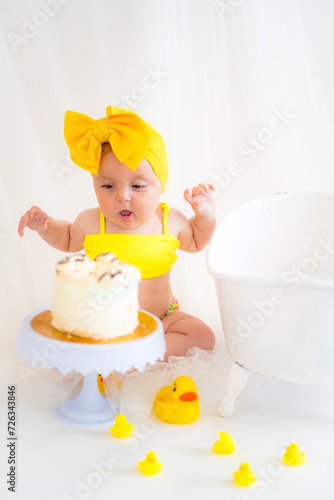 Girl in a yellow swimsuit and birthday cake