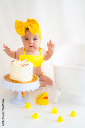 Girl in a yellow swimsuit and birthday cake
