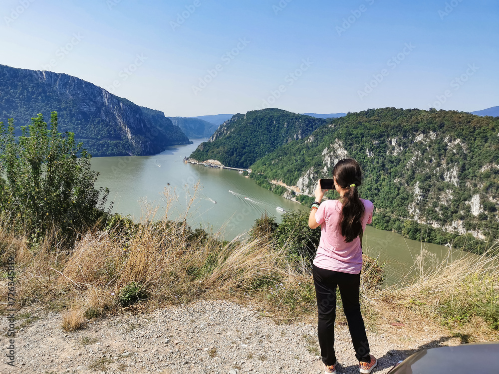 Teenage girl 14-16 photographing mountain scene.Teenager girl explore scenic view