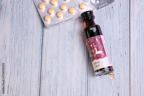 Tiny bottle of lakritz licorice liqueur with pills on the back