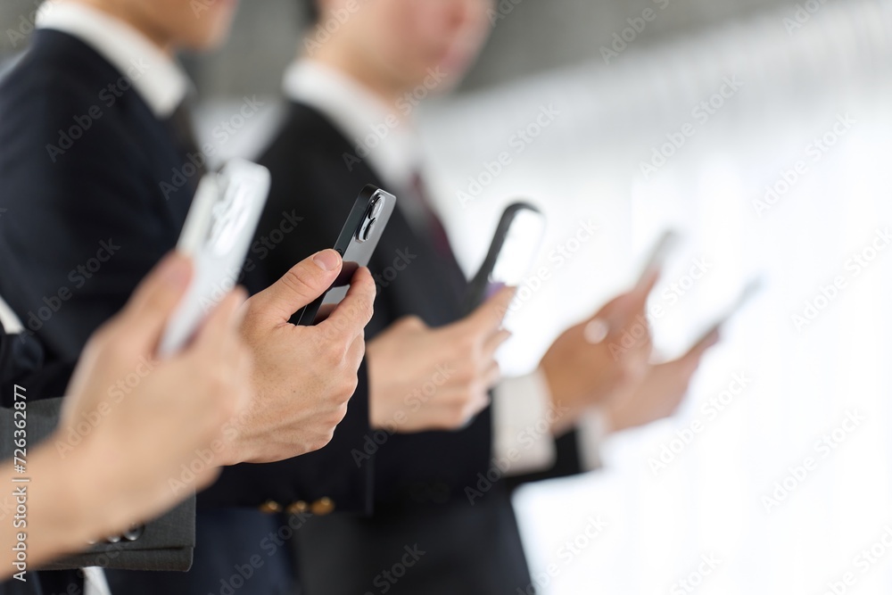 スマートフォンを持つビジネスパーソン