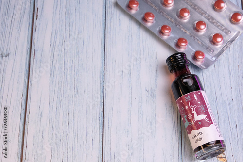 Tiny bottle of lakritz licorice liqueur with red suppliment pills on the back