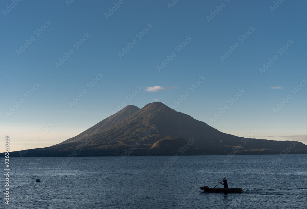 Man in Boat and Atitlan Lake in Guatemala. Long Exposure. Volcano in Background. Morning Light.