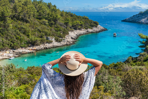 Canvas Print Rear view of young female wearing hat looking at amazing Zitna beach in Zavalati