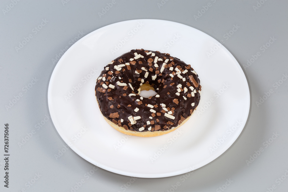 Doughnut with chocolate filling and glaze and sprinkles on dish Doughnut with chocolate filling and glaze and sprinkles on dish
