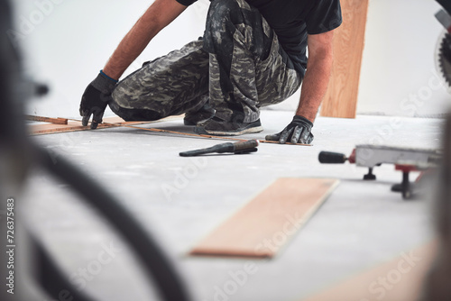 Professional handyman installing laminate flooring in a new apartment. photo